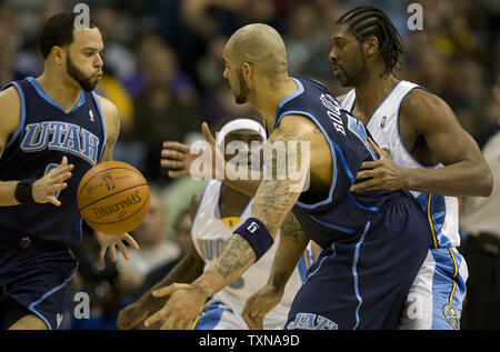 Utah Jazz guard Deron Williams (L) prend la balle de son coéquipier Carlos Boozer (C) contre les Denver Nuggets Ty Lawson et Nene (R) au cours du troisième trimestre au Pepsi Center de Denver le 16 janvier 2010. Denver a battu Utah 119-112. UPI/Gary C. Caskey.. Banque D'Images