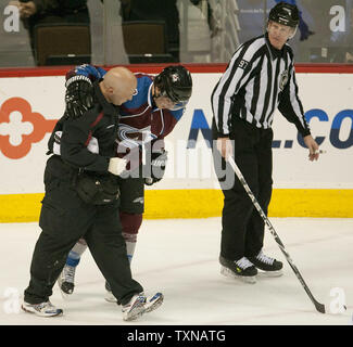 Colorado Avalanche Centre Peter Mueller (C) est aidé hors glace par une avalanche formateur et surveillée par juge Jean Morin (R) au cours de la troisième période à la Pepsi Center le 4 avril 2010 à Denver. Colorado a gagné deux points en battant San Jose en prolongation 5-4. UPI/Gary C. Caskey Banque D'Images