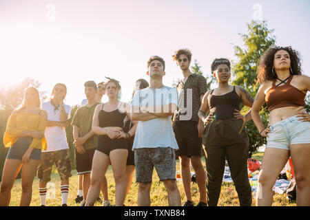 Group of friends posing sous le soleil chaud dans park Banque D'Images