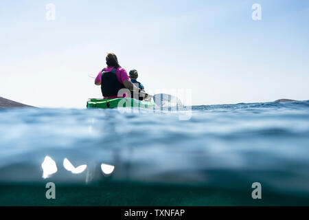 Adolescent et sa mère le kayak de mer, au niveau de la surface vue arrière, Limnos, Calino, Grèce Banque D'Images