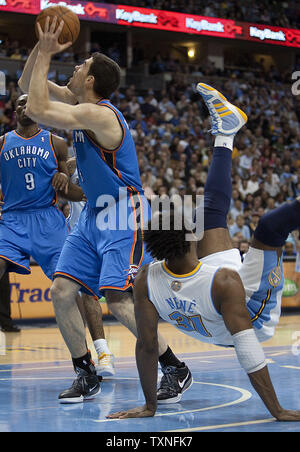 Oklahoma City Thunder avant Nick Collison tire après avoir été souillée par les Denver Nuggets Nene centre (R) du Brésil au cours de la deuxième moitié de la Conférence Ouest Playoffs-First jeu ronde quatre au Pepsi Center de Denver le 25 avril 2011. Éviter un balayage par Denver Oklahoma City 104-101 gagnante. UPI/Gary C. Caskey Banque D'Images