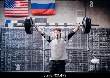 Jeune homme d'haltères de levage in gym Banque D'Images