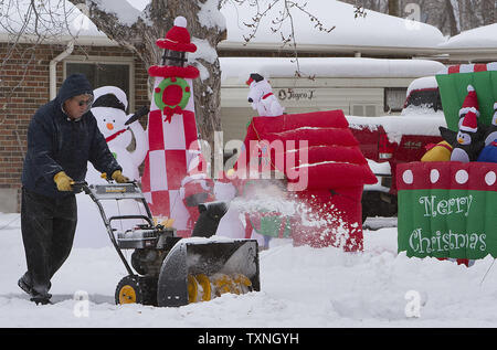 Prendre son temps, un résident efface déneigement des trottoirs près de ses décorations de Noël après une tempête de nuit à Denver le 3 décembre 2011. Denver est attendu à voir de la neige pour les deux prochains jours, comme la tempête continue dans le Colorado. UPI/Gary C. Caskey Banque D'Images