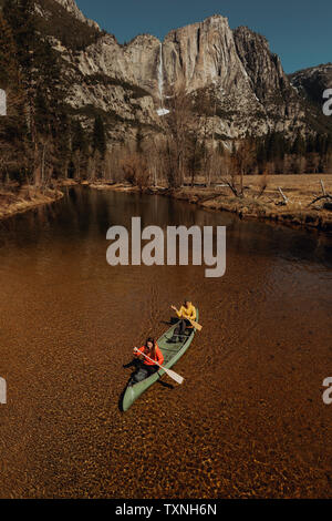Jeune couple canoë canoë sur rivière, high angle view, Yosemite Village, California, USA Banque D'Images