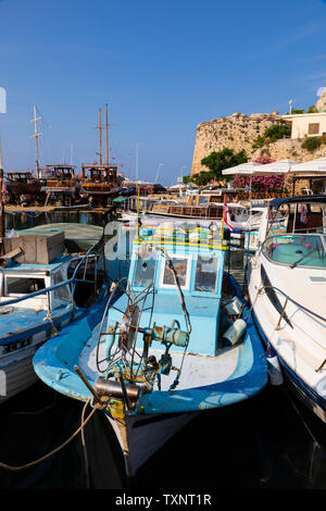 Les bateaux de pêche traditionnels chypriotes amarrée le long d'un bateau moderne, port et château de Kyrenia, Girne, République turque de Chypre du Nord. Banque D'Images