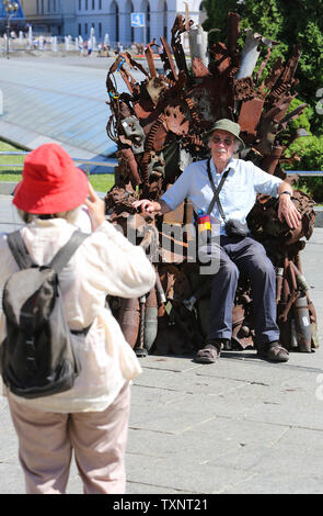 Kiev, Ukraine. 25 Juin, 2019. Prendre des photos des gens assis sur le trône de fer installé à la place de l'Indépendance à Kiev, Ukraine, le 25 juin 2019. ''Le Trône de fer de l'Est'' faites par des bénévoles de l'armée de Denys de Bushtets les pièces d'armures, active MBT une épave, des débris de véhicules, des missiles et des courroies de la cartouche a été exposé dans des flacons de la capitale de l'Ukraine pour rappeler aux habitants de la ville de la guerre. Credit : Sergii Kharchenko/ZUMA/Alamy Fil Live News Banque D'Images