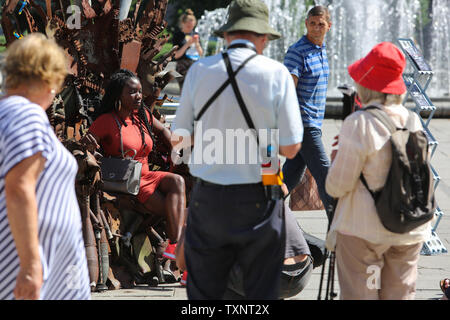 Kiev, Ukraine. 25 Juin, 2019. Prendre des photos des gens assis sur le trône de fer installé à la place de l'Indépendance à Kiev, Ukraine, le 25 juin 2019. ''Le Trône de fer de l'Est'' faites par des bénévoles de l'armée de Denys de Bushtets les pièces d'armures, active MBT une épave, des débris de véhicules, des missiles et des courroies de la cartouche a été exposé dans des flacons de la capitale de l'Ukraine pour rappeler aux habitants de la ville de la guerre. Credit : Sergii Kharchenko/ZUMA/Alamy Fil Live News Banque D'Images