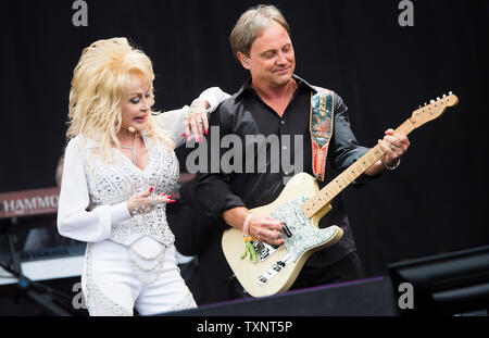 American country star Dolly Parton en spectacle avec son chef d'orchestre Kent Wells sur la Pyramide principale étape du festival de Glastonbury en 2014. Glastonbury Festival of Contemporary Arts de la scène est le plus grand festival de musique au Royaume-Uni, attirant plus de 135 000 personnes chaque à Pilton, Somerset. Banque D'Images