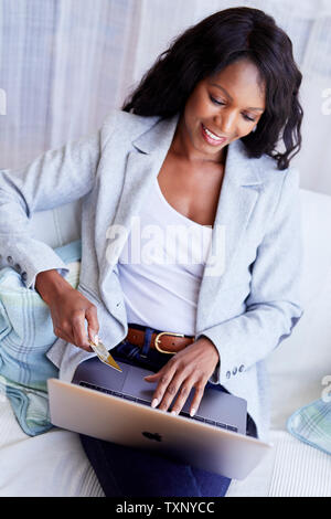 Ethnic woman shopping online using laptop Banque D'Images