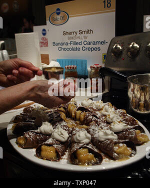 Sherry finaliste Smith de Bunker Hill, West Virginia saupoudre une poignée de noix broyées sur ses crêpes au chocolat rempli de bananes avant de présenter le dessert pour juger au concours Bake-Off de Pillsbury à Dallas le 14 avril 2008. Demain, l'un des compétiteurs de la cuisson à l'hôtel Fairmount va gagner 1 million de dollars. (Photo d'UPI/Robert Hughes) Banque D'Images