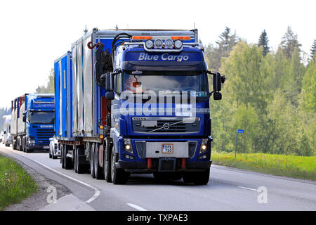 Uurainen, Finlande. Le 7 juin 2019. Camion Volvo FH16 bleu Blue Cargo de Oy tire sur cabines portables en remorque route avec un autre camion. Banque D'Images