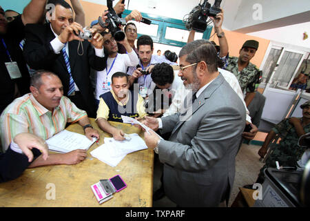 Frères Musulmans égyptiens candidate présidentielle Mohammed Morsi (R), jette son vote à un bureau de scrutin de Zakazik 80 kilomètres (50 milles) au nord du Caire, Egypte le 23 mai 2012. Les égyptiens se sont rendus aux urnes mercredi matin pour élire un nouveau président après la chute de l'ex-Président Hosni Moubarak l'an dernier. UPI/Ahmed Jomaa Banque D'Images