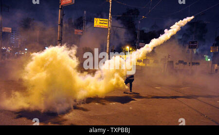 Un manifestant égyptien vers l'arrière une bombe lacrymogène tirée par la police anti-émeute lors d'affrontements près du palais présidentiel au Caire en Egypte, le 1 février 2013. Comme les gens sont descendus dans les rues à travers le pays dans un spectacle de l'opposition à Morsi et ses frères musulmans. La sécurité égyptienne utilisé des canons à eau et ont tiré des coups de feu en l'air comme manifestants ont lancé des cocktails molotov et des pierres sur les motifs du palais présidentiel, a déclaré un porte-parole présidentiel. UPI/Ahmed Jomaa Banque D'Images