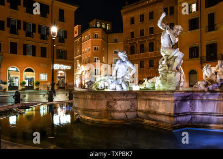 La fontaine de Neptune est éclairé en fin de soirée en tant que touristes quittent les cafés de la Piazza Navona, dans le centre historique de Rome, Italie Banque D'Images