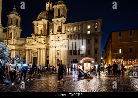 La fin de nuit sur le lumineux colorés de la place Piazza Navona, rempli de touristes, artistes de rue et les vendeurs de souvenirs, à Rome, Italie. Banque D'Images