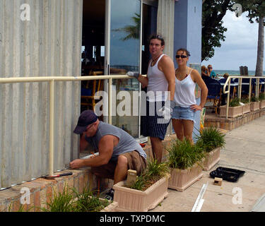 En préparation pour les effets de la tempête tropicale Ernesto, Charlie Brown (L), Dave Williams (C) et Tia Urella accrocher obturateurs d'ouragan à Aruba Beach Cafe à Ft. Lauderdale, Floride le 29 août 2006. Ernesto devrait apporter des vents violents et de la pluie au sud de la Floride pendant les heures du soir et la voie nord à travers la péninsule de Floride. (UPI Photo//Marino-Bill Joe Cantrell) Banque D'Images