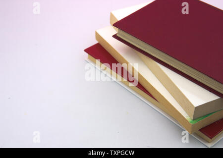 Une pile de livres de différentes couleurs sur un côté de l'image pour ajouter du texte ou des graphiques, copier du texte Banque D'Images
