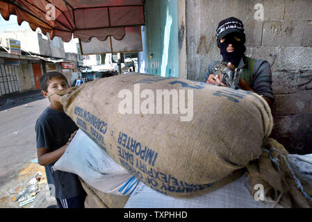 Un militant palestinien montres pour approcher les forces israéliennes de derrière un sac de sable en position défensive à l'intérieur du camp de réfugiés de Jabaliya, le 5 octobre 2004 dans la bande de Gaza. Les militants palestiniens continuent de mettre en place la résistance contre les forces israéliennes, qui en sont à leur sixième jour d'une opération pour créer une zone tampon pour empêcher les militants de tirer des roquettes Qassam sur des villes frontalières et les villes le long de la frontière de Gaza.(UPI Photo/ Ismael Mohamad) Banque D'Images