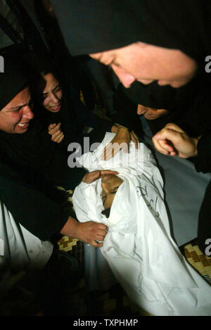 Des proches de 24 ans, Al Qedrh Ebrahem palestiniens pleurent lors de ses funérailles dans le camp de réfugiés de Khan Younes, dans le sud de Gaza le 26 octobre 2004. AL Qedrh a été l'un des 17 Palestiniens tués dans une importante incursion israélienne dans le camp le 25 octobre. (UPI Photo/ Ismael Mohamad) Banque D'Images