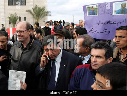 Les hommes de la sécurité palestinienne néerlandais Hendrik Taatgen surround (à gauche) et Brian australienne Ambrosio (en bas à droite) après qu'ils ont été libérés à Gaza le 21 décembre 2005. Le directeur de la prestigieuse American International School, Taatgen, et Ambrosio, son adjoint, ont été immédiatement prises pour la ville de Gaza après leur libération. Les deux hommes avaient été enlevés par des hommes armés, plus tôt dans la journée lorsqu'ils ont été forcés de leur voiture alors qu'ils approchaient de l'école et regroupés dans un autre véhicule. (Photo d'UPI/Ismael Mohamad) Banque D'Images