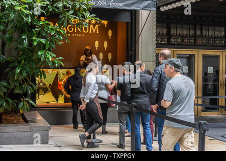 Les amateurs de crème glacée l'étape jusqu'à une fenêtre de Saks Fifth Avenue à New York qui a le verre supprimé et n'est transformé en un "glacier" pour la bonne humeur Co.'s Magnum mini-bar give-away le mardi 18 juin, 2019. Magnum, qui est une marque de bonne humeur, ce qui en soi est administré par le conglomérat géant Unilever, a donné un mini-barre de crème glacée Magnum produits dans différentes saveurs dans la promotion de l'événement. (© Richard B. Levine) Banque D'Images