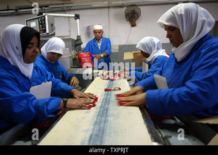 Employés palestiniens se préparer pour l'expédition des boîtes de biscuits et friandises à l'Al-Awda factory à Deir al-Balah, dans le centre de Gaza le 17 septembre 2007. L'usine, la production de biscuits faits que localement dans les territoires palestiniens, des visages fermeture possible en raison du manque de matières premières et de la difficulté à distribuer des marchandises à travers les terminaux pilotés israélienne crossing à la Cisjordanie. (Photo d'UPI/Ismael Mohamad) Banque D'Images