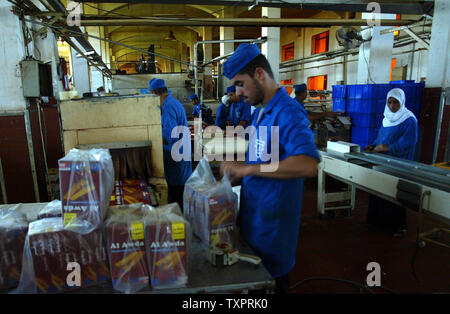 Employés palestiniens se préparer pour l'expédition des boîtes de biscuits et friandises à l'Al-Awda factory à Deir al-Balah, dans le centre de Gaza le 17 septembre 2007. L'usine, la production de biscuits faits que localement dans les territoires palestiniens, des visages fermeture possible en raison du manque de matières premières et de la difficulté à distribuer des marchandises à travers les terminaux pilotés israélienne crossing à la Cisjordanie. (Photo d'UPI/Ismael Mohamad) Banque D'Images