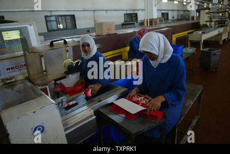 Employés palestiniens se préparer pour l'expédition des boîtes de biscuits et friandises à l'Al-Awda factory à Deir al-Balah, dans le centre de Gaza le 17 septembre 2007. L'usine, la production de biscuits faits que localement dans les territoires palestiniens, des visages fermeture possible en raison du manque de matières premières et de la difficulté à distribuer des marchandises à travers les terminaux pilotés israélienne crossing à la Cisjordanie. (Photo d'UPI/Ismael Mohamad) Banque D'Images