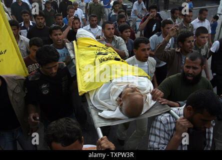 Transporter le corps du défunt palestinien de Yussef Abu Daher, 60 ans, lors de ses funérailles à Khan Younis dans le sud de la bande de Gaza le 24 mars 2008. Le 55-year-old palestinien a été abattu près du village Al-Qarara par des soldats israéliens qui ont ouvert le feu à partir d'un poste militaire près du passage de Kissufim, selon des témoins. (Photo d'UPI/Ismael Mohamad) Banque D'Images