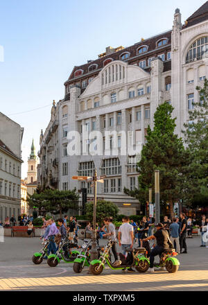 Electric Scooters pneus gras garé dans le centre de Budapest, la Hongrie à l'heure d'or Banque D'Images