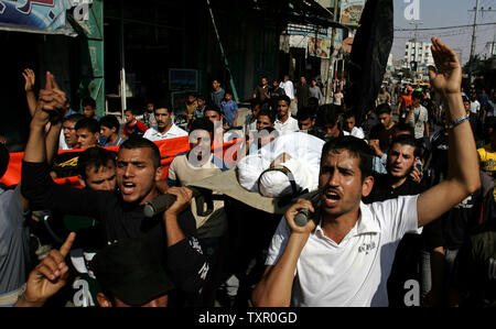Palestiniens crier des slogans comme ils portent le corps des militants du Djihad islamique Yassin, 19 Jasser, et Abdelmajid Saleh, 18 ans, au cours de leurs funérailles à Rafah, dans le sud de la bande de Gaza le 22 mai 2009. (Photo d'UPI/Ismael Mohamad) Banque D'Images