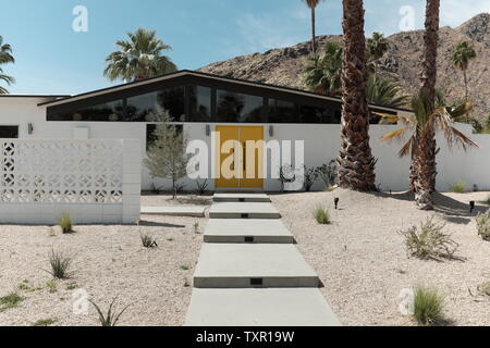 Maison moderniste de milieu de siècle conçue avec des portes jaunes et des blocs de brise dans une maison de désert à Palm Springs, Californie, États-Unis. Banque D'Images