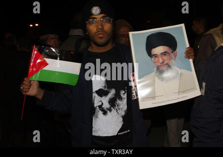 Certains des 100 activistes avec l 'Europe 1' aid convoy tenir portraits d'Iran l'Ayatollah Ali Khamenei (R) et la fin de la république islamique, l'Ayatollah Khamenei fondateur, alors qu'ils traversent dans le sud de la bande de Gaza par la frontière de Rafah avec l'Egypte, dès le 3 janvier 2011. La cargaison d'aide devrait arriver à Gaza plus tard dans la journée, après avoir voyagé séparément de la Syrie à l'Egypte par bateau. Ismael Mohamad/UPI Banque D'Images