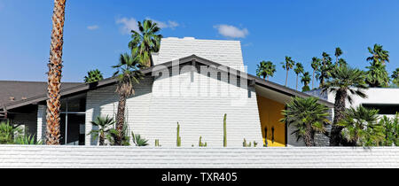 Maison de design moderne du milieu du siècle avec toit à pignons, portes jaunes, palmiers, et flore du désert à Palm Springs, Calfornia, Ohio, États-Unis. Banque D'Images