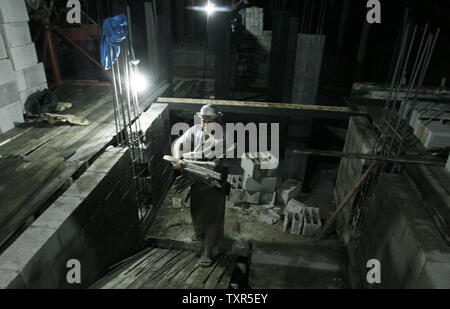 Les travailleurs de la construction palestinienne travaillent la nuit à Rafah dans le sud de Gaza le 27 juillet 2012. Les travailleurs palestiniens travailler la nuit pendant le mois de Ramadan en raison des températures diurnes. Aussi les travailleurs ne peuvent pas travailler pendant la journée lorsqu'ils sont à jeun. Ismael Mohamad/UPI Banque D'Images