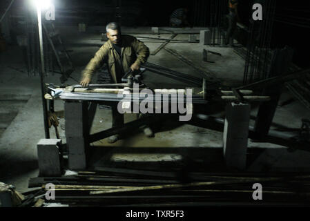 Les travailleurs de la construction palestinienne travaillent la nuit à Rafah dans le sud de Gaza le 27 juillet 2012. Les travailleurs palestiniens travailler la nuit pendant le mois de Ramadan en raison des températures diurnes. Aussi les travailleurs ne peuvent pas travailler pendant la journée lorsqu'ils sont à jeun. Ismael Mohamad/UPI Banque D'Images