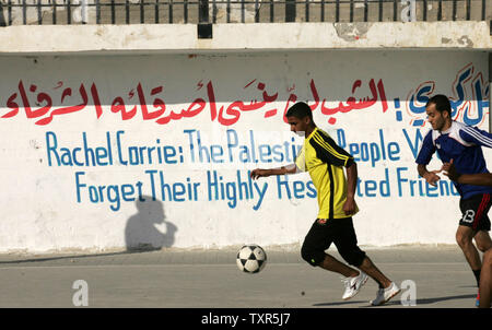 Des jeunes Palestiniens jouent au football dans un camp de réfugiés à Rafah, dans le sud de la bande de Gaza, le 28 juillet 2012, à la fin d'un match de football local, nommé le "Rachel Corrie Cup', en l'honneur de l'activiste de la paix qui a été écrasé par un bulldozer israélien au cours d'une manifestation contre la démolition de maisons près de la frontière de Rafah, dans le sud de la bande de Gaza avec l'Égypte en 2003. La famille Corrie avait accusé Israël d'avoir tué illégalement et intentionnellement leurs 23 ans en mars 2003, le lancement d'une affaire civile dans le nord de la ville de Haïfa après une enquête militaire a trouvé l'armée n'a pas r Banque D'Images