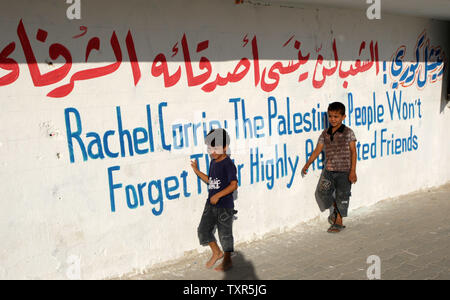 Les garçons palestiniens à pied dans un camp de réfugiés à Rafah, dans le sud du Strip, le 28 juillet 2012, et regarder un match de football local, nommé le "Rachel Corrie Cup', en l'honneur de l'activiste de la paix qui a été écrasé par un bulldozer israélien au cours d'une manifestation contre la démolition de maisons près de la frontière de Rafah, dans le sud de la bande de Gaza avec l'Égypte en 2003. La famille Corrie avait accusé Israël d'avoir tué illégalement et intentionnellement leurs 23 ans en mars 2003, le lancement d'une affaire civile dans le nord de la ville de Haïfa après une enquête militaire a trouvé l'armée n'était pas responsable. UPI/Isma Banque D'Images