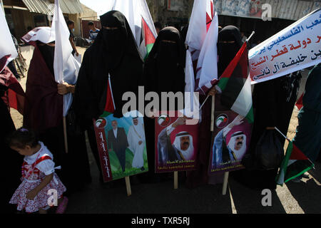 APalestinian femmes portent des photos de l'Émir du Qatar Cheikh Hamad bin Khalifa al-Thani, près de la frontière de Rafah avec l'Egypte avant l'arrivée de l'Émir du Qatar, Cheikh Hamad bin Khalifa al-Thani à la bande de Gaza, le 23 octobre 2012. Cheikh Hamad bin Khalifa al-Thani est situé à arriver dans la bande de Gaza, pour la première visite d'un chef de l'Etat depuis le mouvement islamiste Hamas a pris le pouvoir en 2007. Ismael Mohamad/UPI Banque D'Images