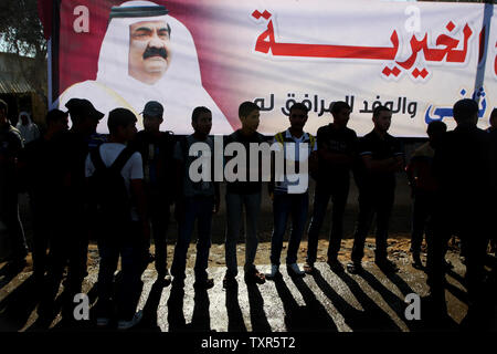 Les jeunes palestiniens se tiennent près des photos de l'Émir du Qatar Cheikh Hamad bin Khalifa al-Thani, près de la frontière de Rafah avec l'Egypte avant l'arrivée de l'Émir du Qatar, Cheikh Hamad bin Khalifa al-Thani à la bande de Gaza, le 23 octobre 2012. Cheikh Hamad bin Khalifa al-Thani est situé à arriver dans la bande de Gaza, pour la première visite d'un chef de l'Etat depuis le mouvement islamiste Hamas a pris le pouvoir en 2007. Ismael Mohamad/UPI Banque D'Images