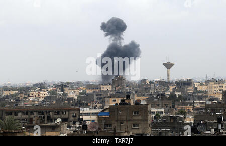 La fumée monte à la suite d'une frappe aérienne israélienne dans la ville de Rafah, dans le sud de Gaza, le 13 mars 2014. L'aviation israélienne a mené des raids sur 29 cibles à Gaza la nuit, frapper temporaires utilisées par les militants de la décision du mouvement Hamas à Gaza et de l'aile armée du Jihad islamique, les brigades Al-qods, qui a fait à ce jour l'ensemble de la fusée. Un cessez-le-feu négocié par l'Egypte le jeudi pour mettre fin à une flambée de roquettes à partir de Gaza sur des villes israéliennes et des raids aériens israéliens dans l'enclave palestinienne, le groupe militant du Jihad islamique a dit. Ismael Mohamad/UPI Banque D'Images