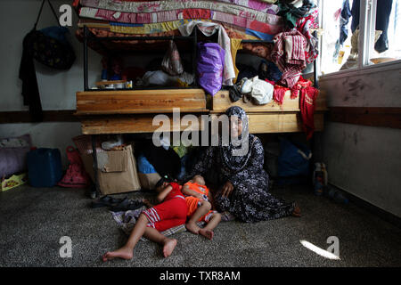 Les Palestiniens déplacés s'abriter à l'Organisation des Nations Unies pour l'école dans le camp de réfugiés de Rafah, dans le sud de la bande de Gaza le 30 juillet 2014. Au début des bombardements israéliens le 30 juillet tué 'dozens" des Palestiniens de Gaza, dont au moins 16 dans une école de l'ONU, les membres du dit, au jour 23 de la Israel-Gaza conflit. Ismael Mohamad/UPI Banque D'Images