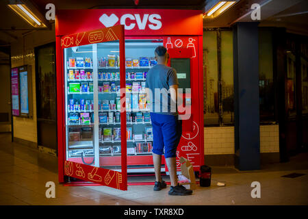 Un travailleur ajuste une marque CVS distributeur de matériel divers assortis dans l'Union Square à New York, le samedi 22 juin, 2019. Après un nombre incalculable d'années depuis la suppression des distributeurs automatiques de métros, un test de deux CVS high-tech de marque de distributeurs automatiques ont été placés dans l'Union Square et de la rue Chambre d'affectation. Actuellement, 40  % de l'ATM espaces commerciaux sont inoccupées. (© Richard B. Levine) Banque D'Images