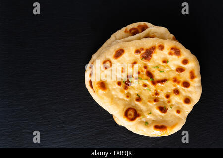 Concept alimentaire yaourts bio faits maison sur pain naan black slate board with copy space Banque D'Images