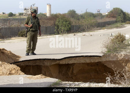 Un membre des forces de sécurité palestiniennes fidèles au Hamas monte la garde à un glissement de terrain provoqué par l'eau pompée par les forces égyptiennes pour détruire les tunnels de contrebande de biens palestiniens, près de la frontière entre l'Egypte et le sud de la bande de Gaza, le 26 novembre 2015. Photo par Ismael Mohamad/UPI Banque D'Images