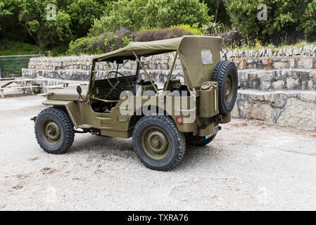 Une époque de la Seconde Guerre mondiale Willys Jeep garée sur le béton à la plage Polgwidden dans le jardin de Trebah dans les Cornouailles. Banque D'Images