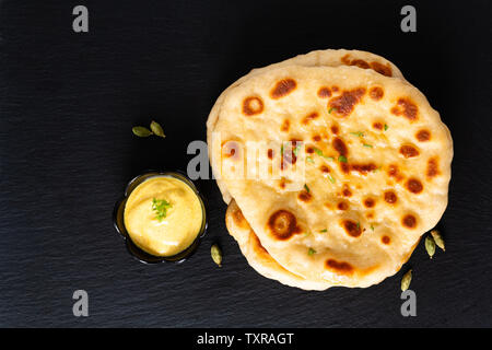 Concept alimentaire yaourts bio faits maison sur pain naan black slate board with copy space Banque D'Images