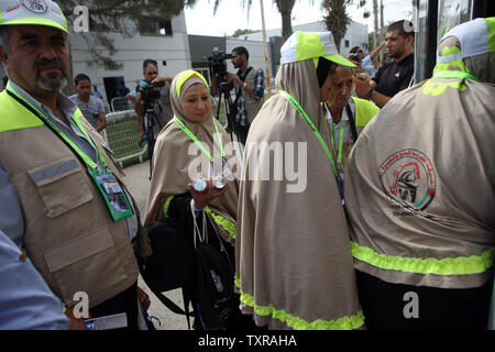 Pèlerins musulmans palestiniens arrivent à la frontière de Rafah entre l'Egypte et le sud de la bande de Gaza, le 30 août 2016 avant leur départ pour le hajj annuel pèlerinage en Arabie Saoudite, ville sainte de La Mecque. Le gouvernement égyptien a fermé la frontière avec Gaza ouvre presque toujours quelques jours au cours de l'année l'Egypte a décidé de maintenir le passage ouvert pour trois jours afin de permettre à deux mille de personnes à traverser. Photo par Ismael Mohamad/UPI. Banque D'Images