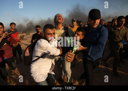 Des manifestants palestiniens transporte un homme blessé à l'écart de la scène d'affrontements avec les forces israéliennes au cours de protester contre la frontière Israel-Gaza à Rafah, dans le sud de la bande de Gaza, le 7 septembre 2018. Un Palestinien a été tué et des dizaines de blessés, une source médicale a dit. Photo par Ismael Mohamad/UP Banque D'Images