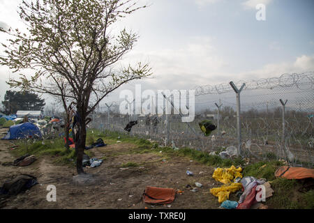 La corbeille est éparpillés à travers le sol et coincé dans les barrières à l'extérieur d'un camp de réfugiés en Grèce. Les mères, les enfants et les familles sont parmi les 12 000 réfugiés bloqués dans un camp de fortune en Idomeni, Grèce, le long de la frontière avec la Macédoine en avril 2016 après la fermeture de la frontière. Photo de David Caprara/UPI Banque D'Images